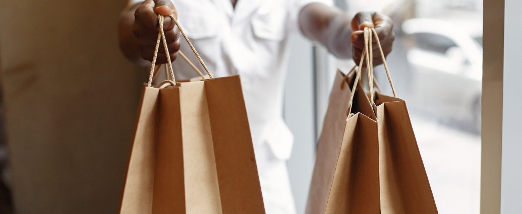 Black man in a cafe. Guy with shopping bags. Man in a white shirt.