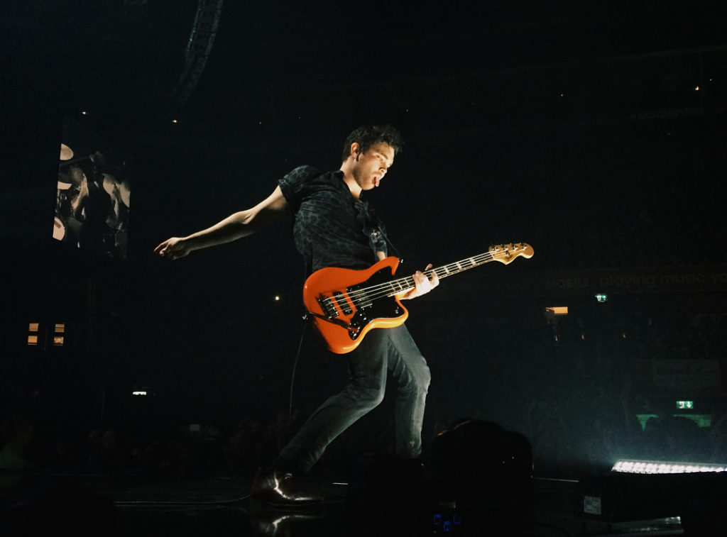 Royal Blood's guitarist Mike Kerr playing a guitar on stage