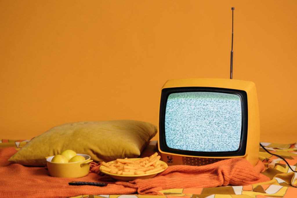 tv in front of yellow background with food