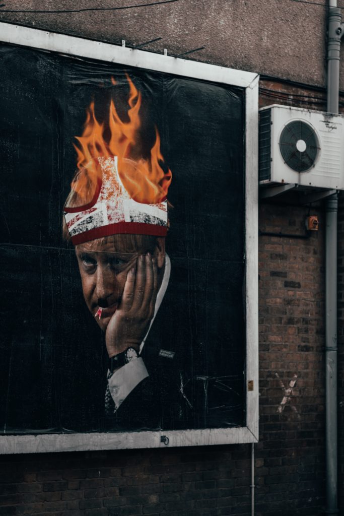 billboard image showing boris johnson with pants on fire on his head