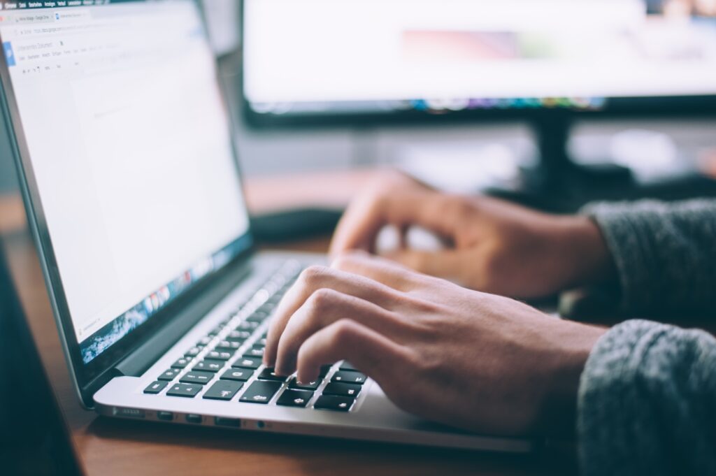 Hands typing on laptop keyboard