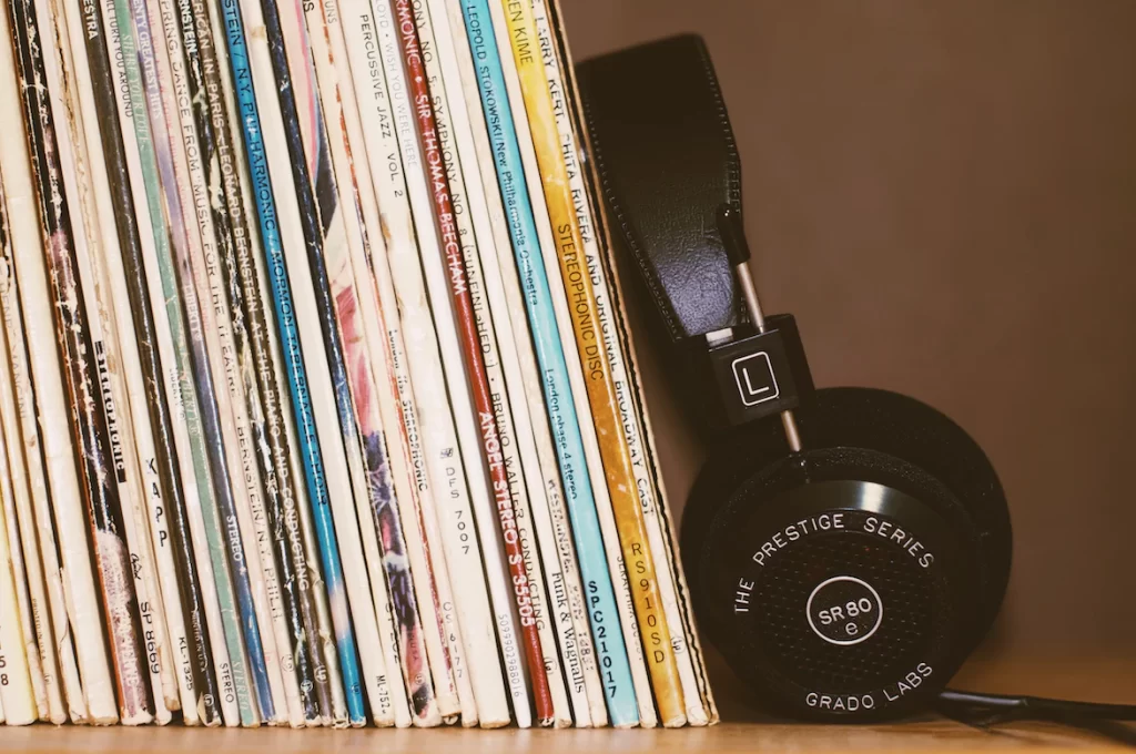 records resting on a shelf next to a pair of headphones