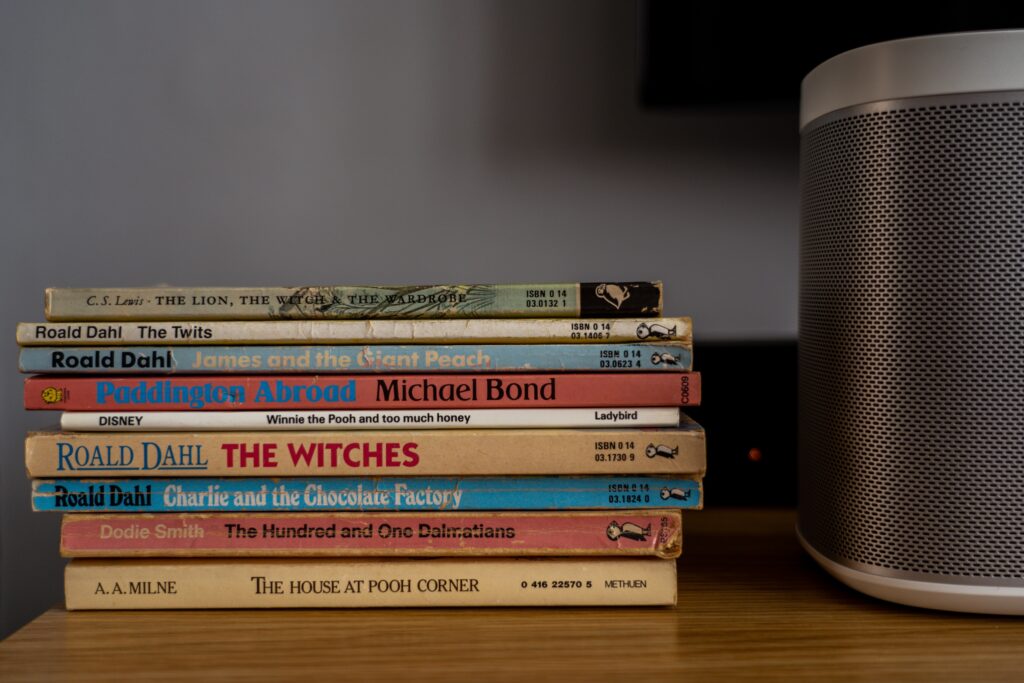 A stack of Roald Dahl books lying down on a shelf.