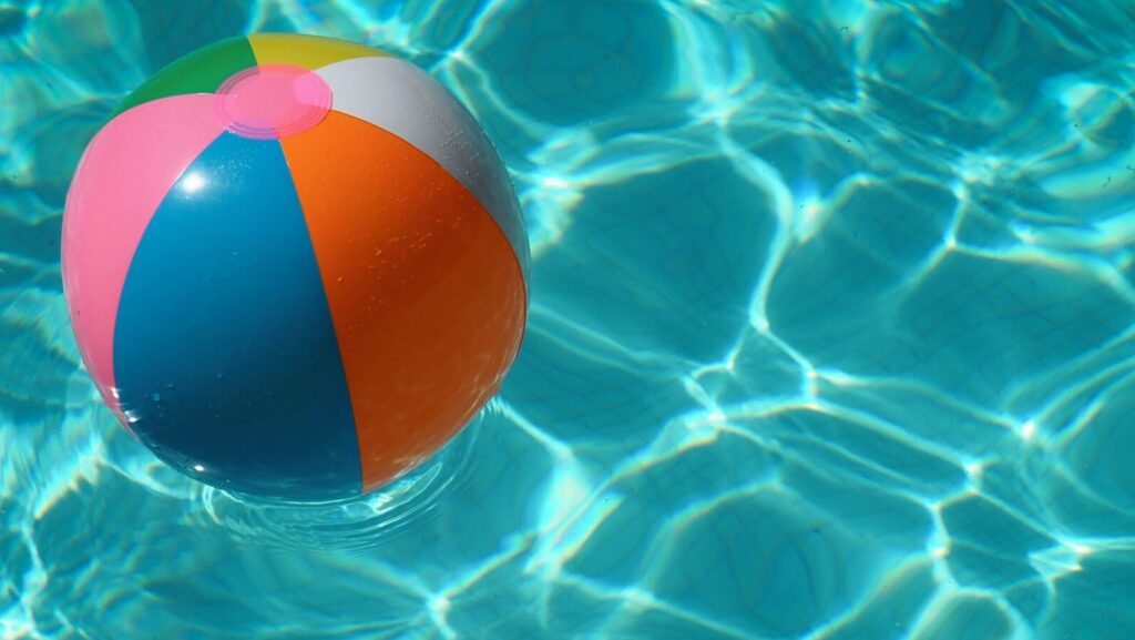 Beach ball in a clear blue swimming pool