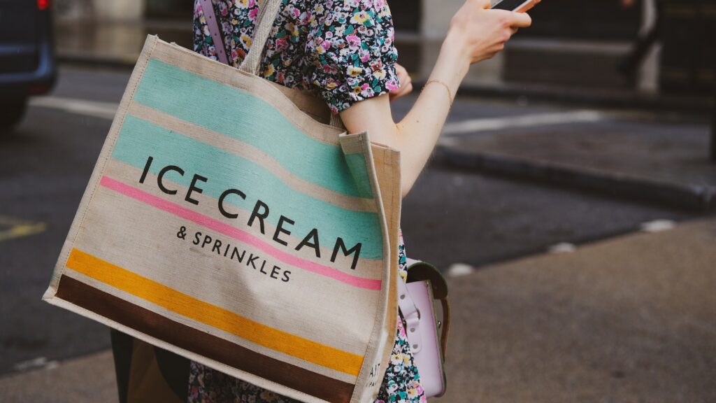 a person carrying a multi-coloured tote bag