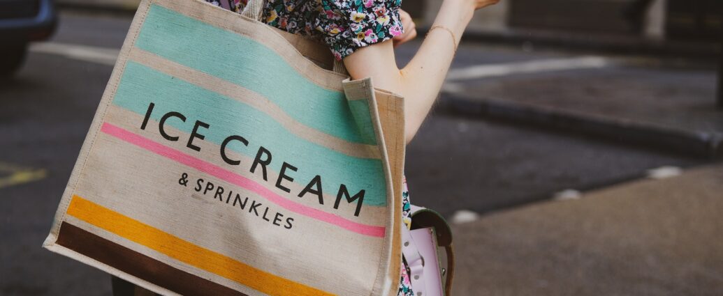 a person carrying a multi-coloured tote bag