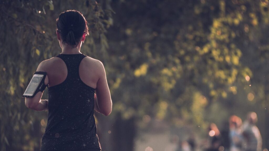 A woman running through a wooded area.