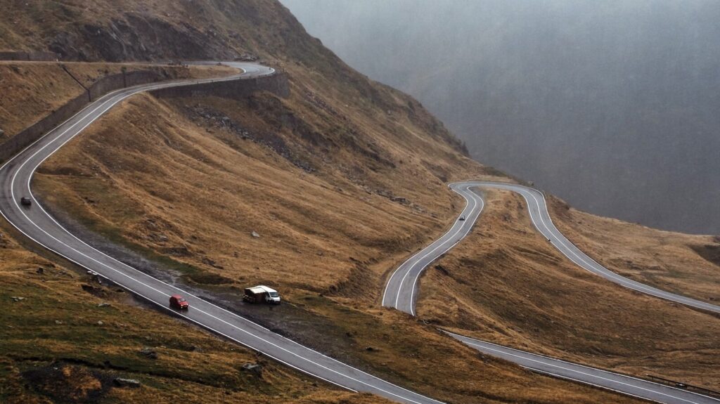 A winding road on a hillside in Romania.