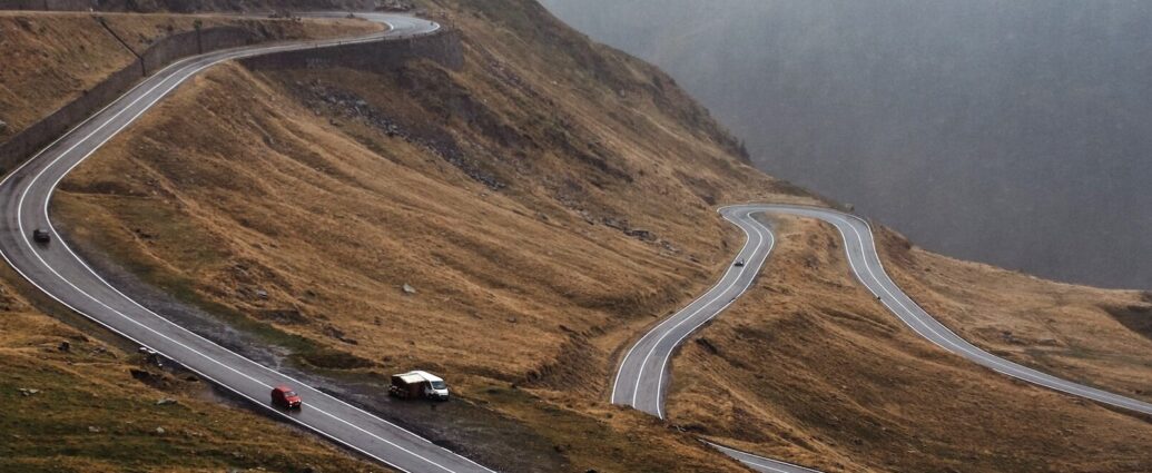 A winding road on a hillside in Romania.