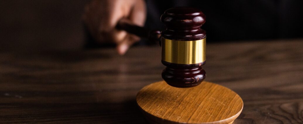 A wooden gavel is struck against a sound block.