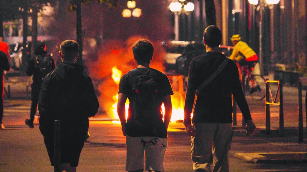 A group of people watching a fire during protests against police violence in France.