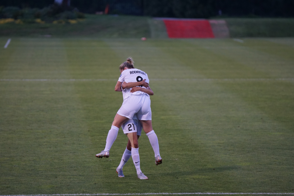 two England lionesses celebrating on the pitch