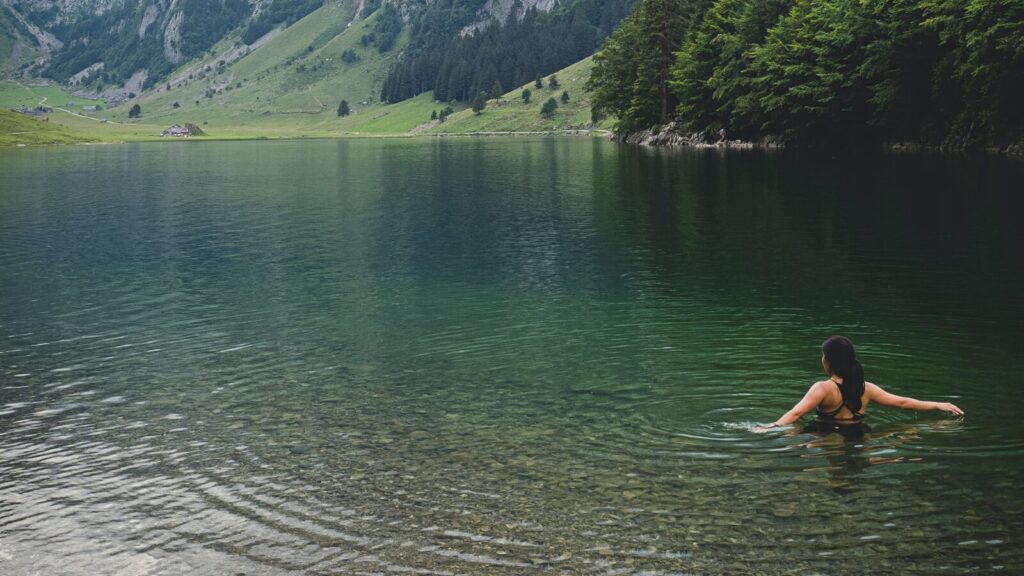 Image shows a woman cold water swimming in a lake