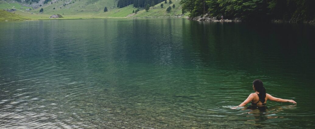 Image shows a woman cold water swimming in a lake