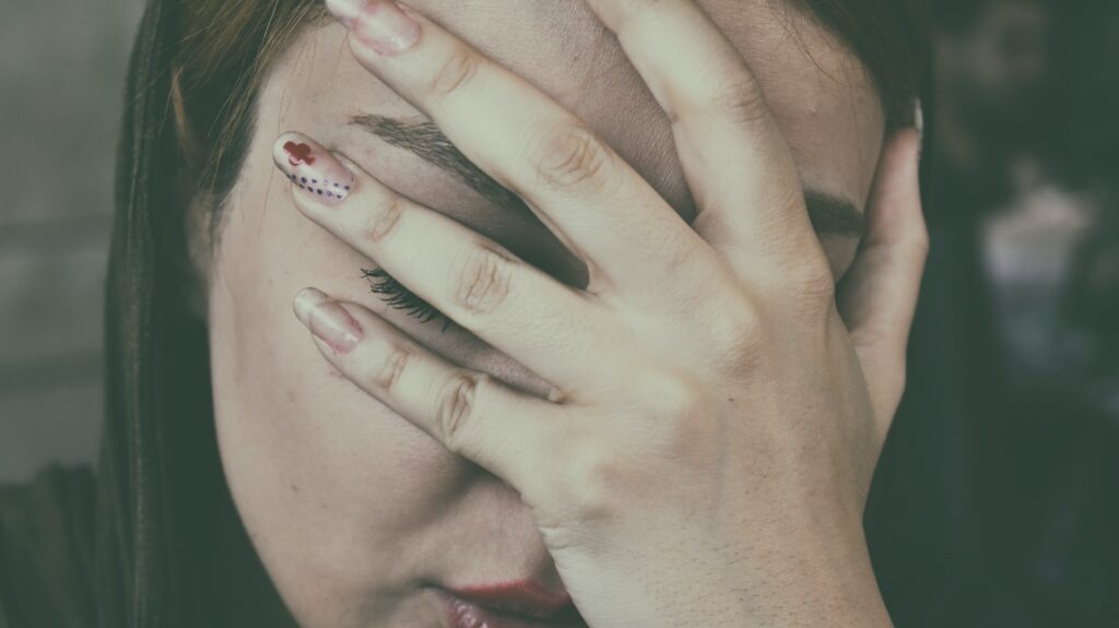 A woman with a migraine clutching her head.