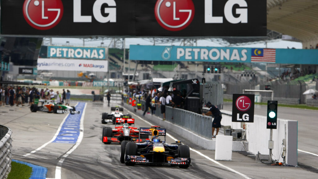 Image shows cars racing beneath an LG banner at the Grand Prix.