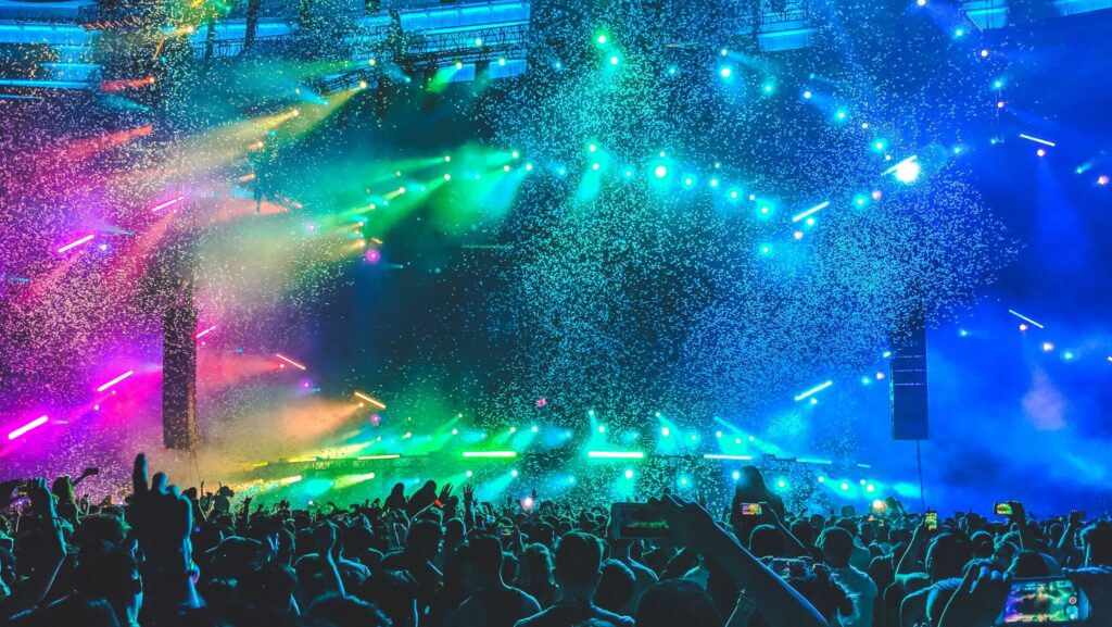 pink, green, and blue lights illuminating a concert stage.