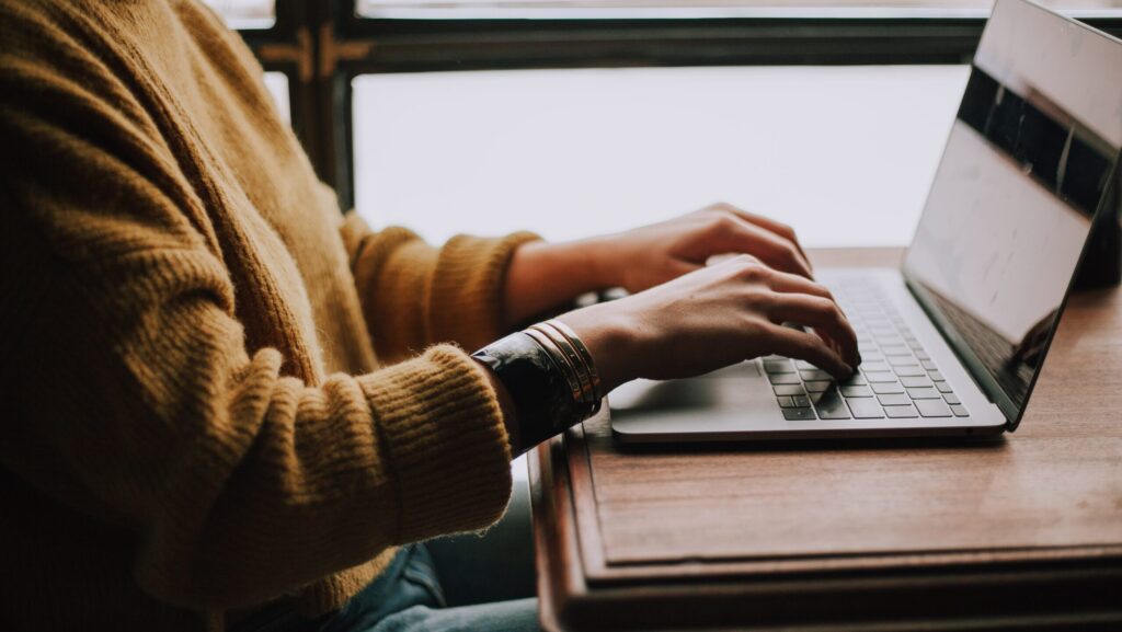 Pair of hands at a laptop keyboard upon a desk. Ghost-written.