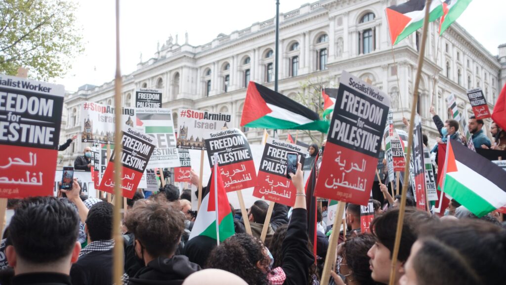 Israel-Palestine conflict. Citizens hold signs protesting the occupation of Palestine