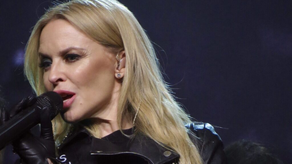 Blonde Kylie Minogue sings passionately into microphone