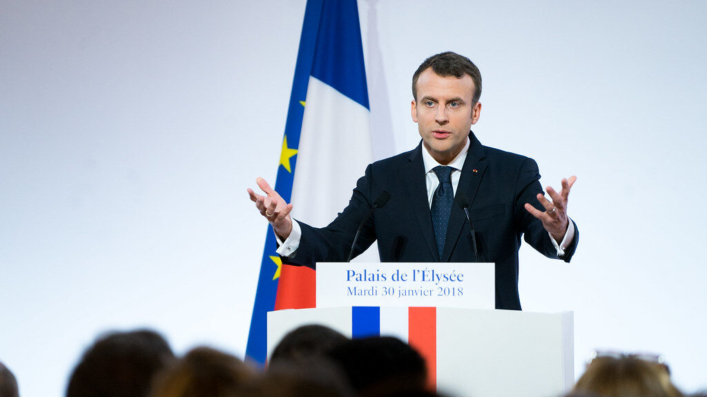 President Macron delivers a speech at a lectern.