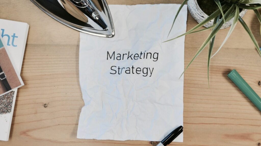 Image shows a piece of paper on a desk with the words 'marketing strategy' printed onto it [FOMO marketing]