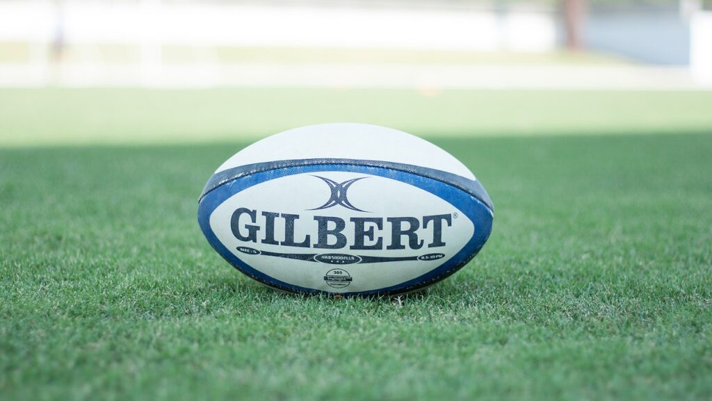 Blue and white rugby ball placed on green grass at Six Nations rugby pitch