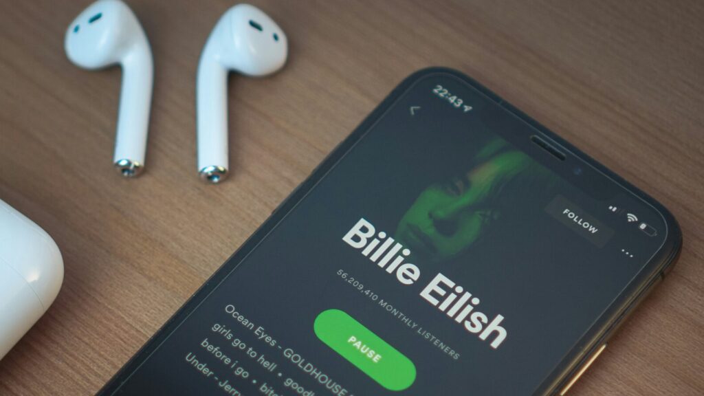 A phone plays a Billie Eilish album on Spotify.