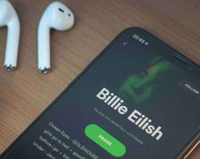 A phone plays a Billie Eilish album on Spotify.