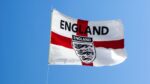 England flag (Red Cross over white) with English football team logo on it against blue sky