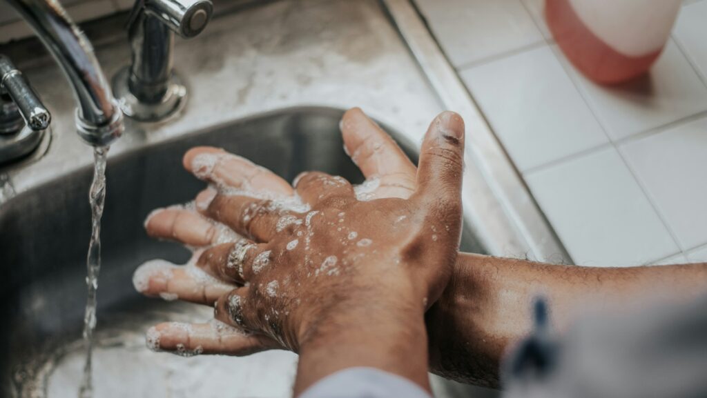 person washing their hands over sink