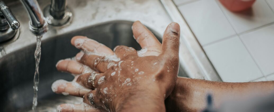 person washing their hands over sink