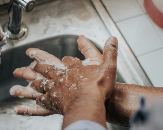 person washing their hands over sink