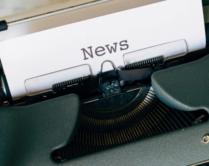 A piece of white paper in a type writer reading the word 'News'. My Journalism Journey