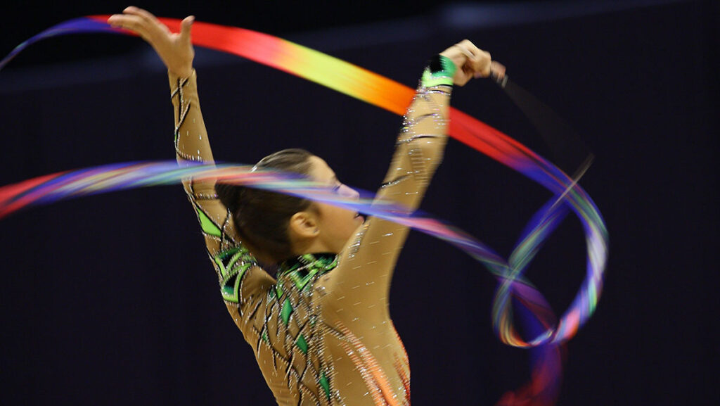 female gymnast flinging colourful ribbon. women in the olympics