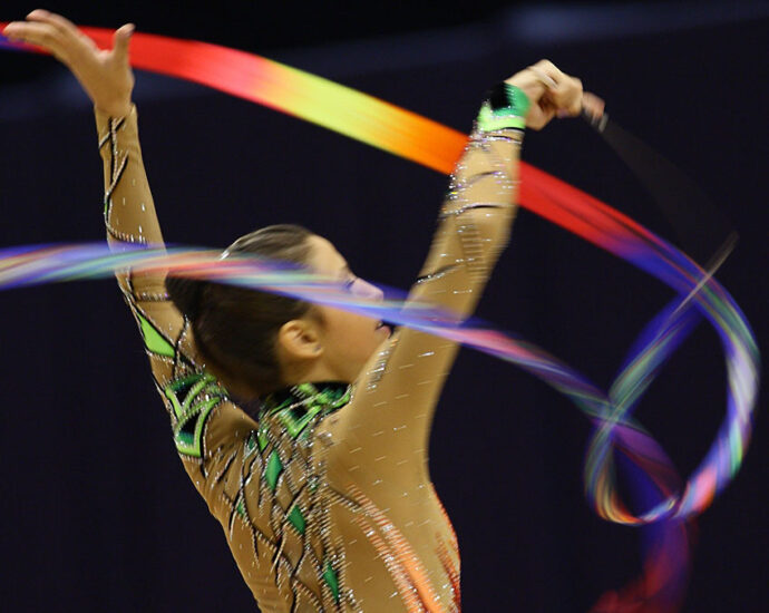 female gymnast flinging colourful ribbon. women in the olympics