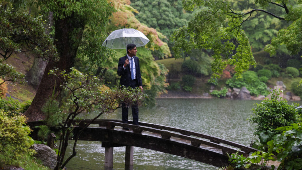 Rishi Sunak stands in the rain with an umbrella. The UK said goodbye to Sunak as its PM after the landslide achieved by Labour in the General Election 2024