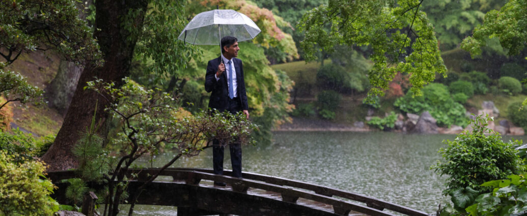 Rishi Sunak stands in the rain with an umbrella. The UK said goodbye to Sunak as its PM after the landslide achieved by Labour in the General Election 2024