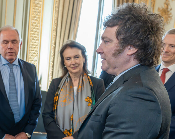 Image of Argentinian PresidentJavier Milei with other Argentinian government officials in suits.