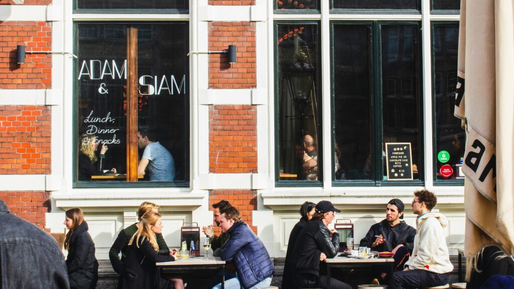 People sitting outside a cafe talking over coffee