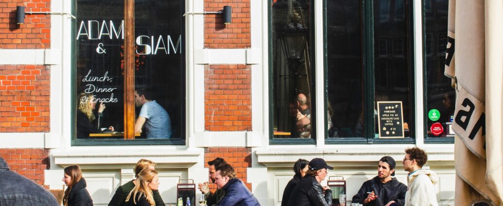 People sitting outside a cafe talking over coffee