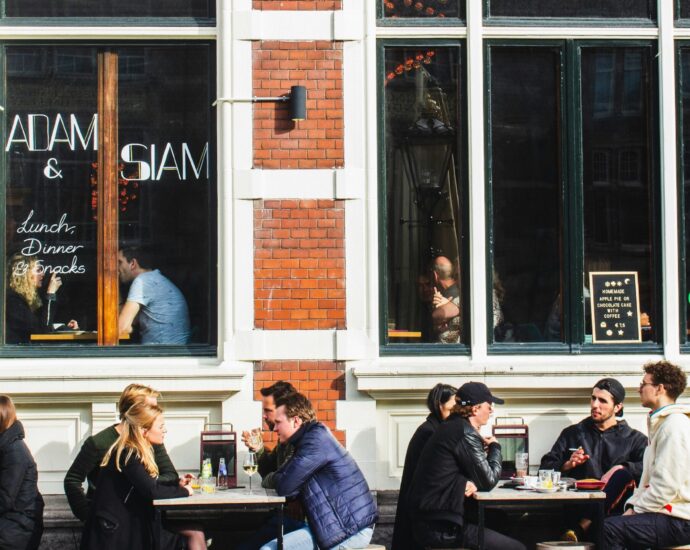 People sitting outside a cafe talking over coffee