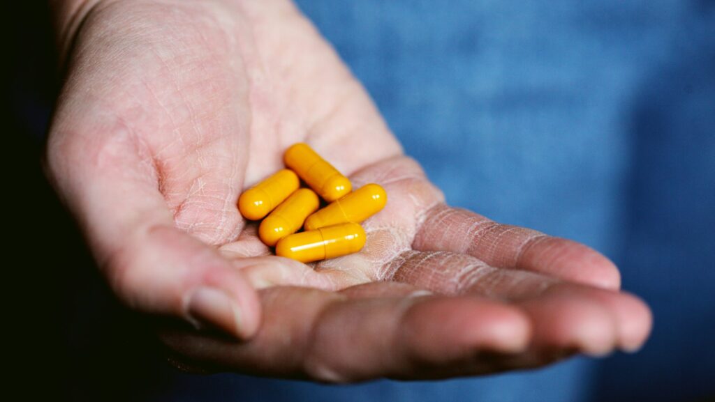 Yellow medication pills on persons hand