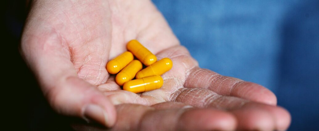 Yellow medication pills on persons hand