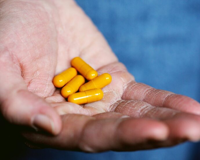 Yellow medication pills on persons hand