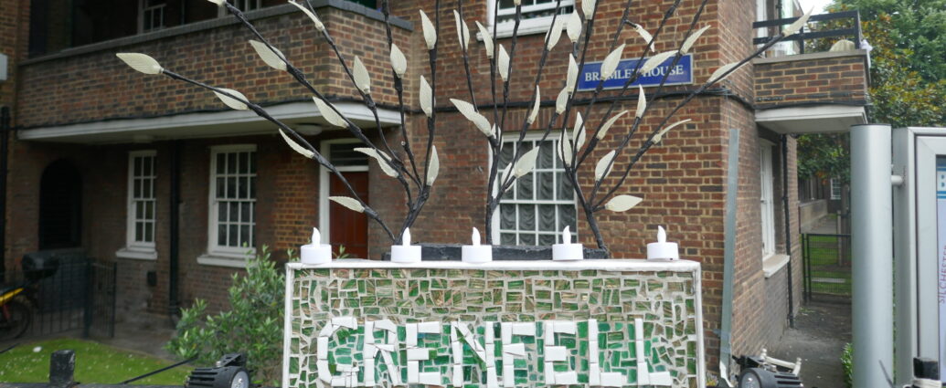 a Grenfell memorial outside brown building made from green and white mosaic tiles.