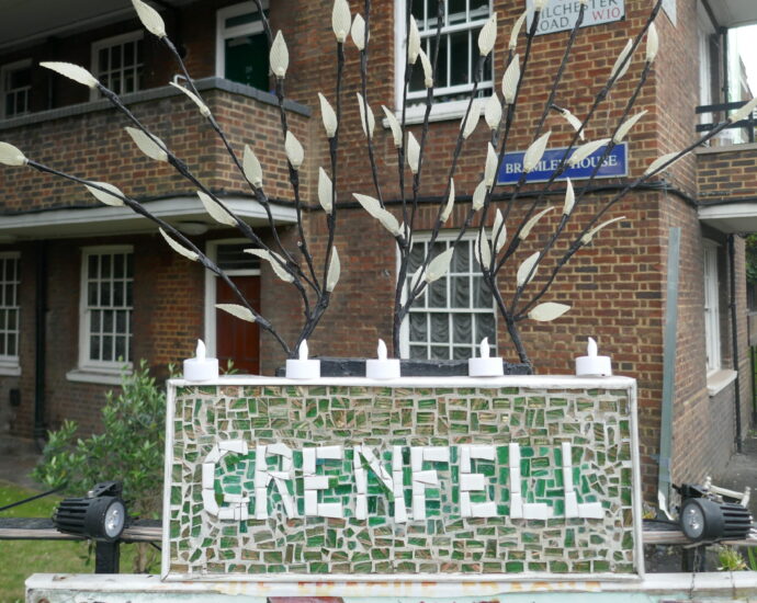 a Grenfell memorial outside brown building made from green and white mosaic tiles.