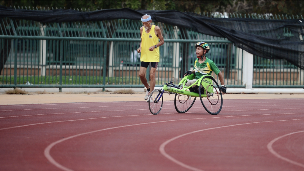 man using a green wheelchair on racing track