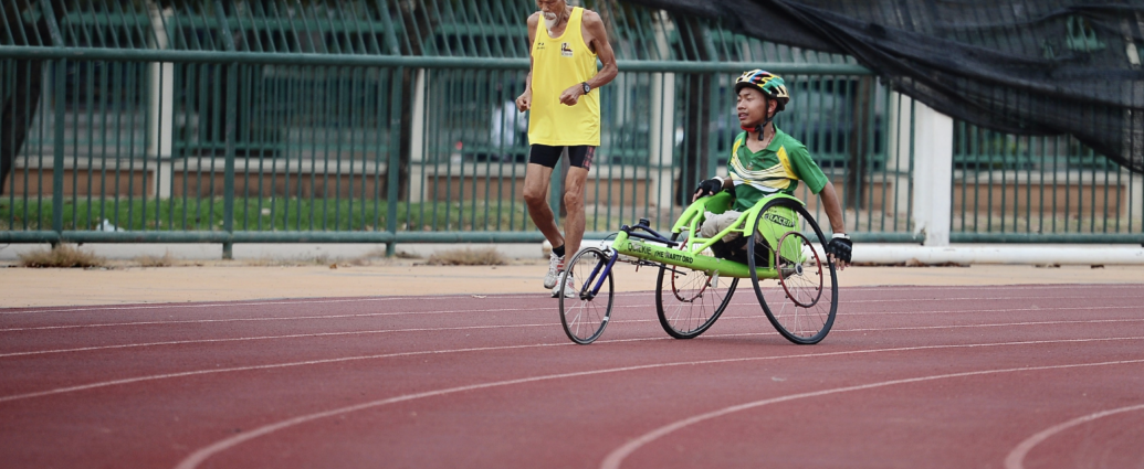 man using a green wheelchair on racing track