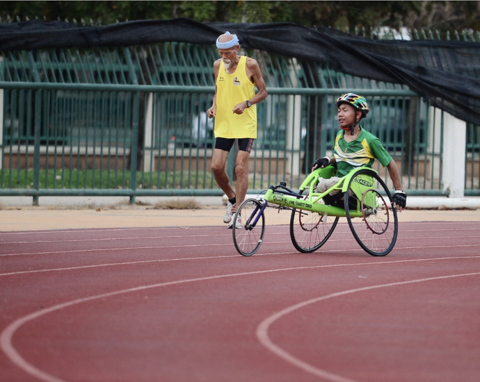 man using a green wheelchair on racing track